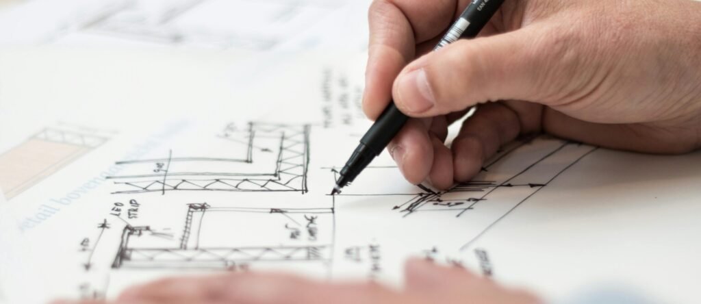 pexels-photo-1109541-1109541-1 Close-up of hand drawing intricate technical designs on blueprint with pen, ideal for engineering or architecture themes.