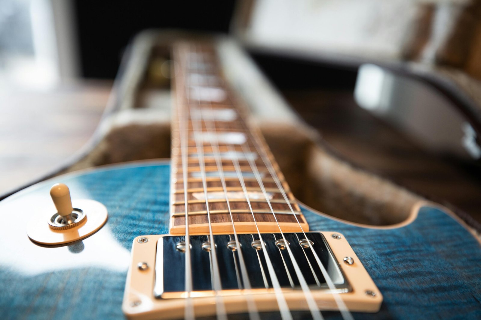 A detailed close-up of an electric guitar showing the strings and frets.